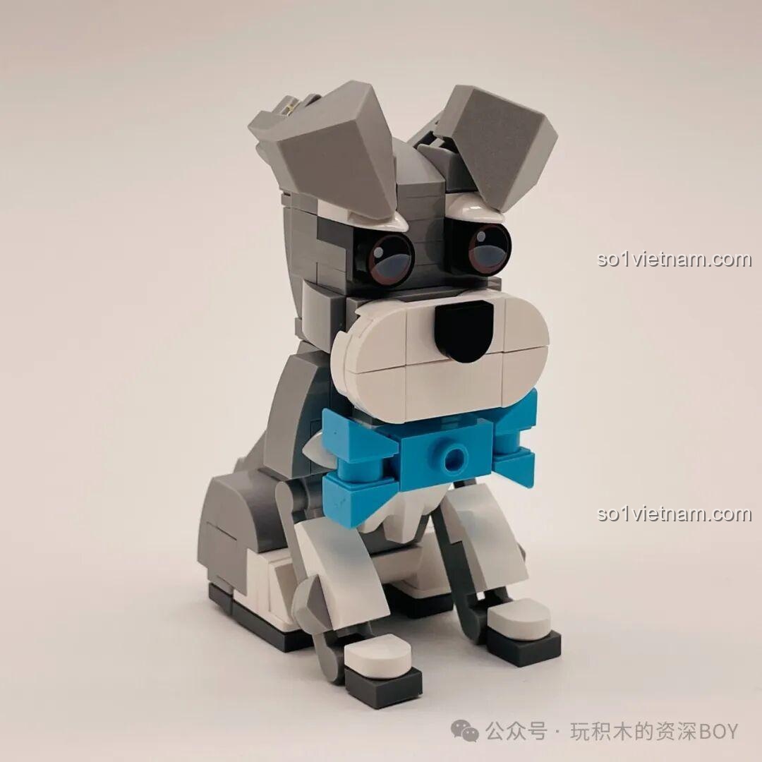 Mô hình chó Schnauzer JAKI JK8130 đã hoàn thành, ngồi ngoan ngoãn với chiếc nơ xanh và đôi mắt