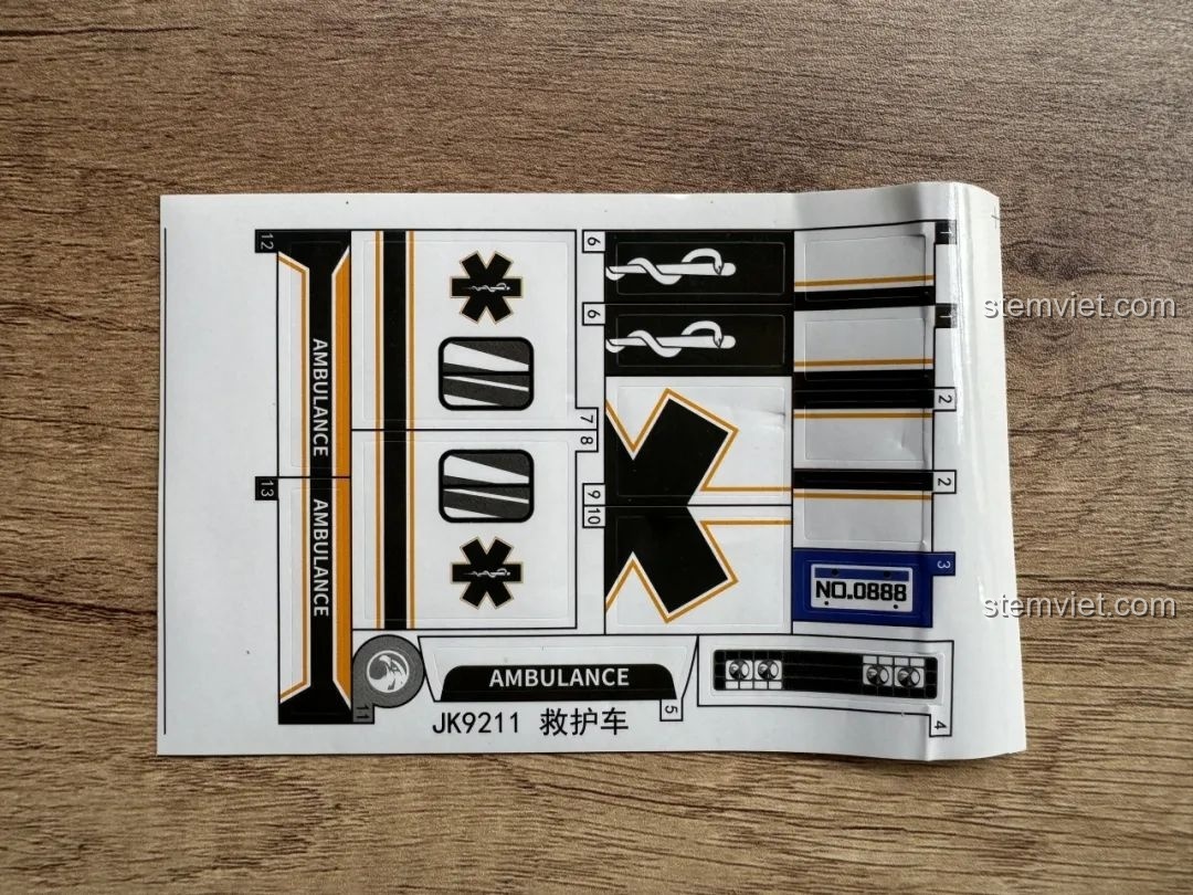 Tấm decal với các chi tiết trang trí như logo, biển số, và sọc phản quang cho xe cứu thương JAKI JK9211.