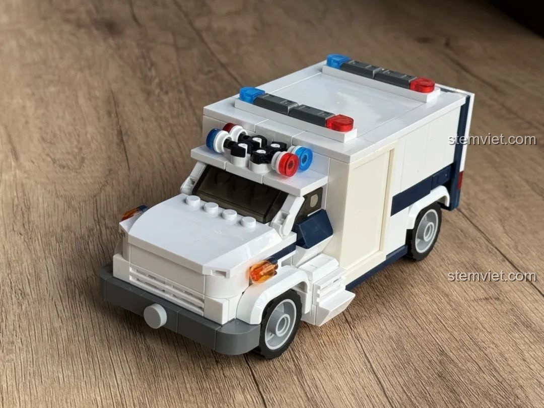 Mô hình xe cứu thương JAKI JK9211 đã hoàn thiện, nhìn từ góc 3/4 phía trước bên phải, chi tiết rõ nét.