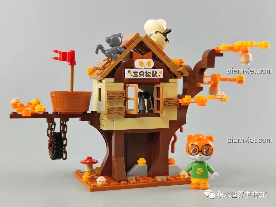 Bên trong hộp bộ lắp ráp JAKI Nhà Cây Trong Rừng với các túi chi tiết và sách hướng dẫn, mang tông màu mùa thu ấm áp.