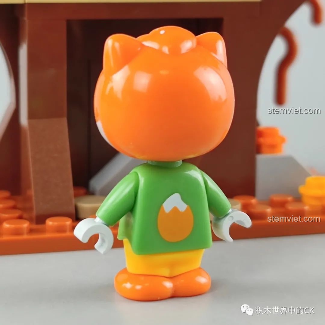 Cận cảnh minifigure sóc đeo kính trong bộ JAKI Nhà Cây, mặc áo màu xanh lá cây in hình hạt dẻ và quần vàng.