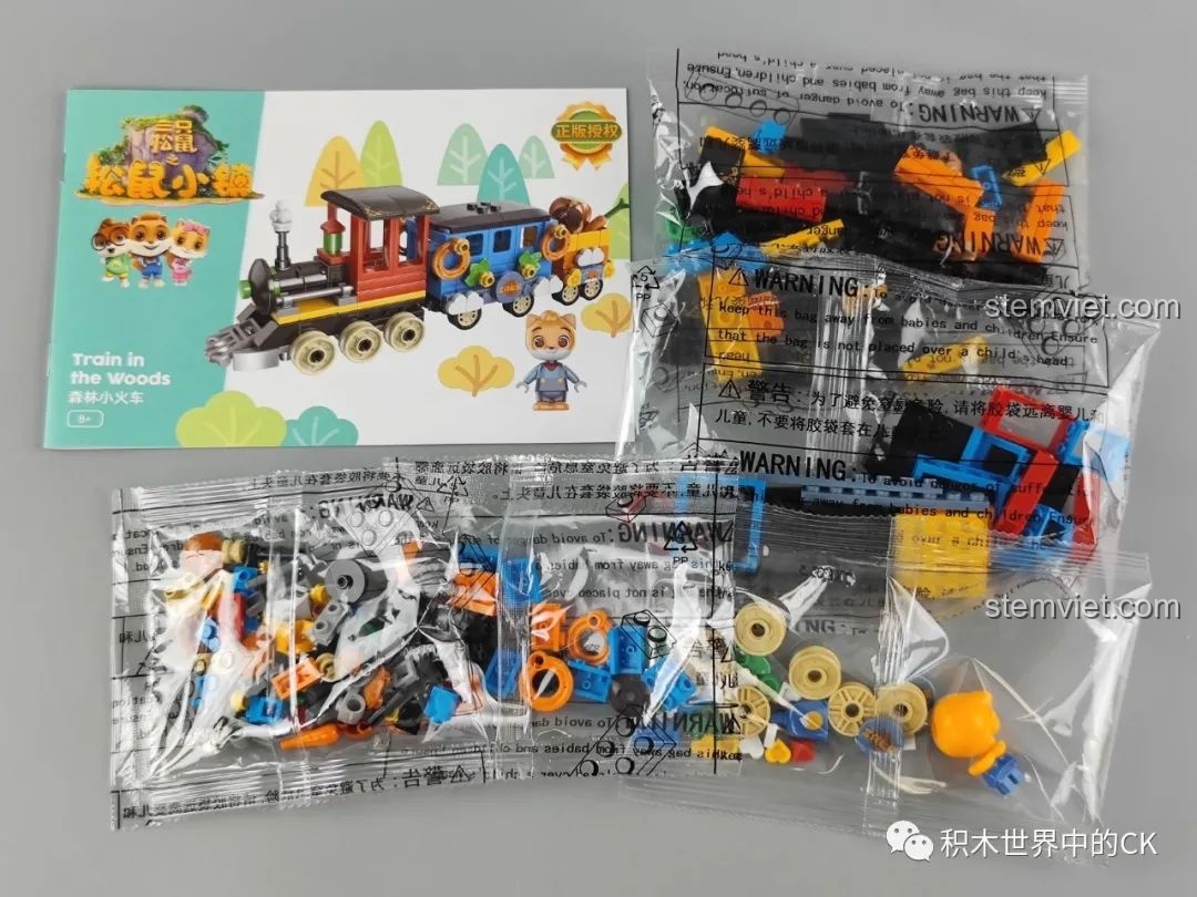 Bên trong hộp bộ lắp ráp JAKI Tàu Hỏa Rừng Xanh gồm các túi chi tiết và sách hướng dẫn, sẵn sàng cho việc lắp ráp.