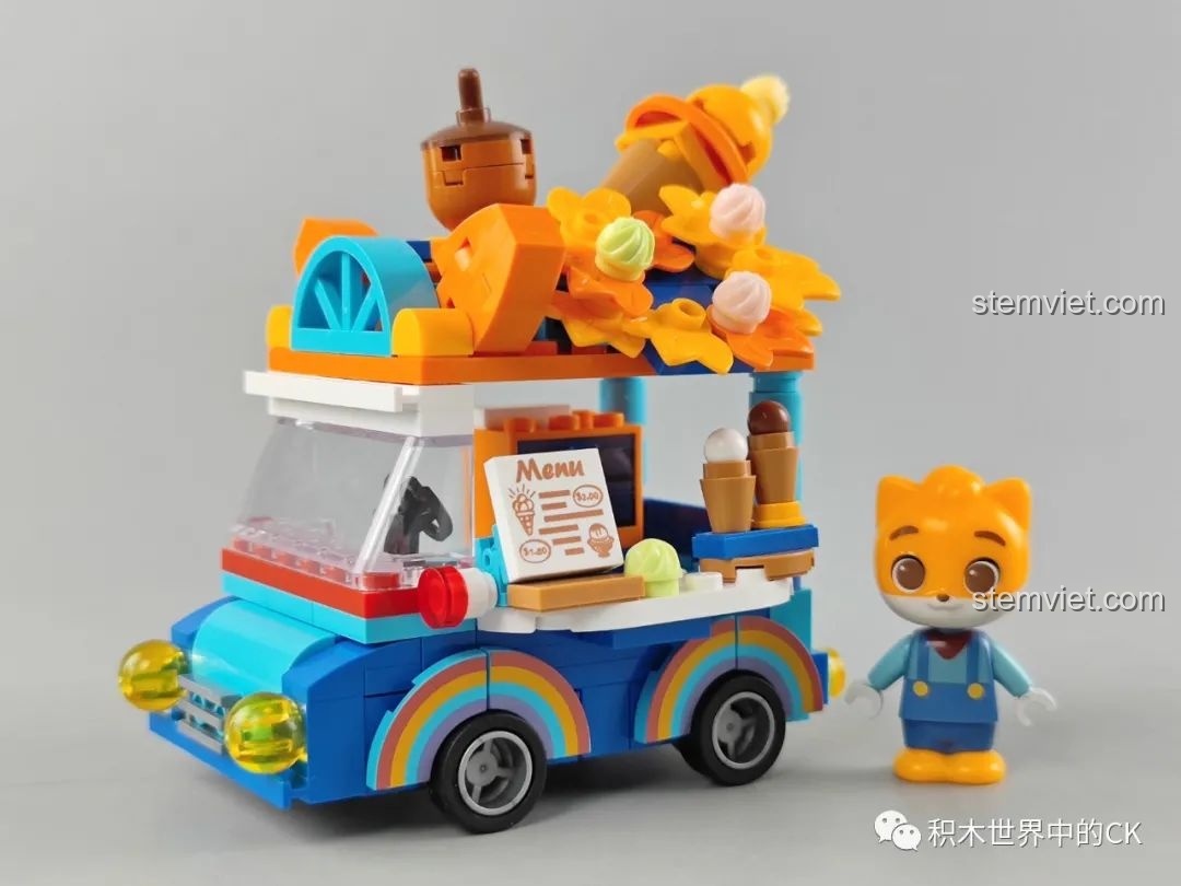 Bên trong hộp bộ lắp ráp JAKI Xe Kem Ngon Lành với các túi chi tiết nhiều màu sắc và sách hướng dẫn lắp ráp.