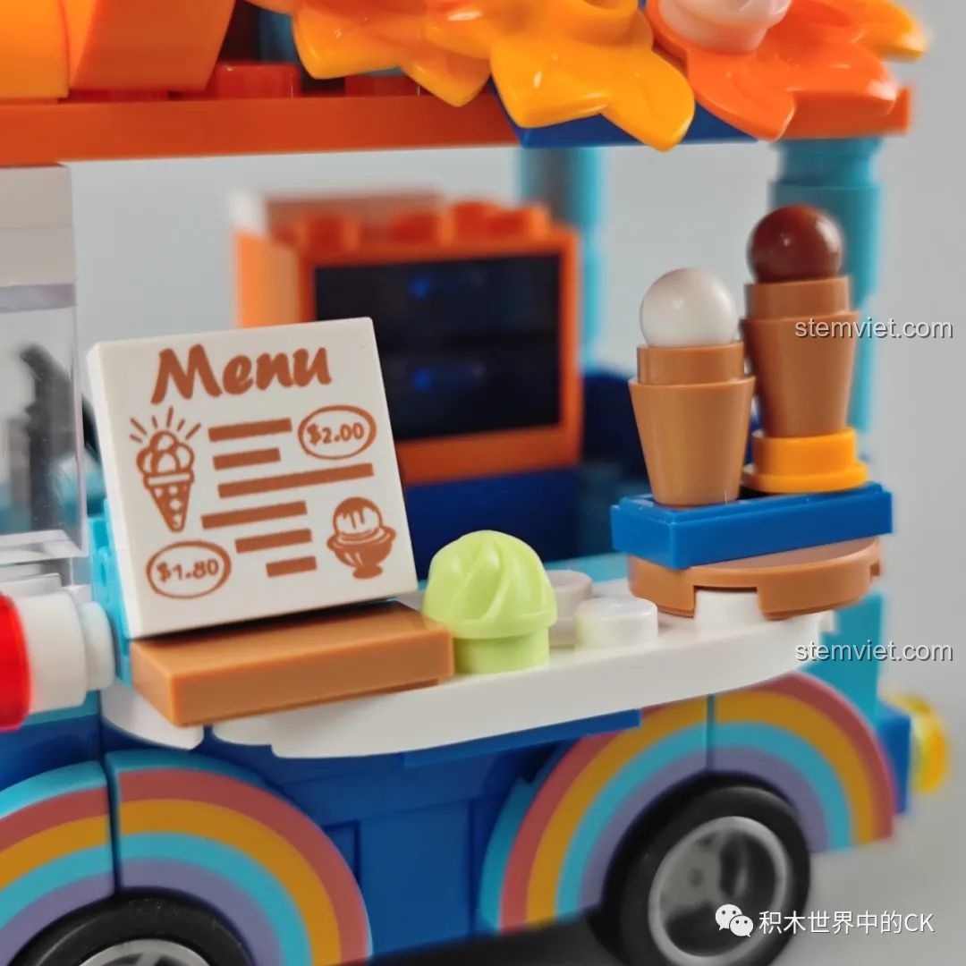 Cận cảnh chi tiết in hình cầu vồng trên vòm bánh xe của xe kem JAKI, màu sắc pastel nhẹ nhàng và sắc nét.