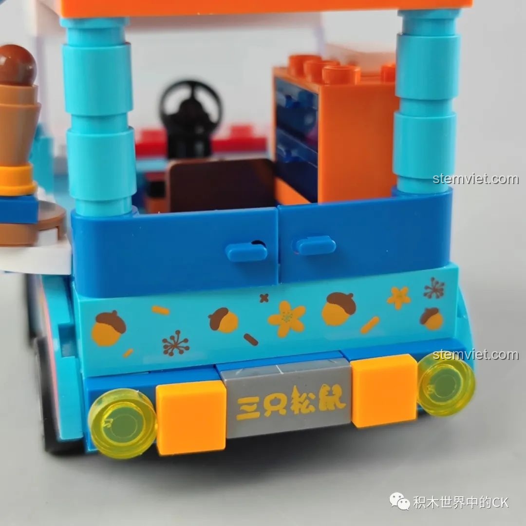 Chi tiết trang trí trên nóc xe kem JAKI, bao gồm một cây kem ốc quế lớn, hạt dẻ và các bông hoa kem nhiều màu.