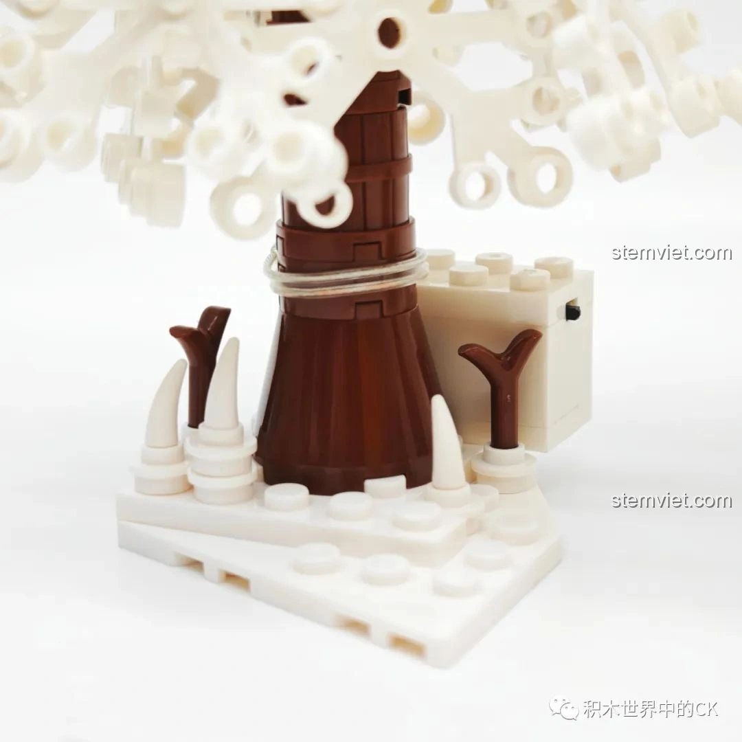 Chi tiết gốc cây thông phủ tuyết của bộ JIESTAR 89141 Ngôi nhà Giáng Sinh, với các mảnh ghép tuyết nhỏ.