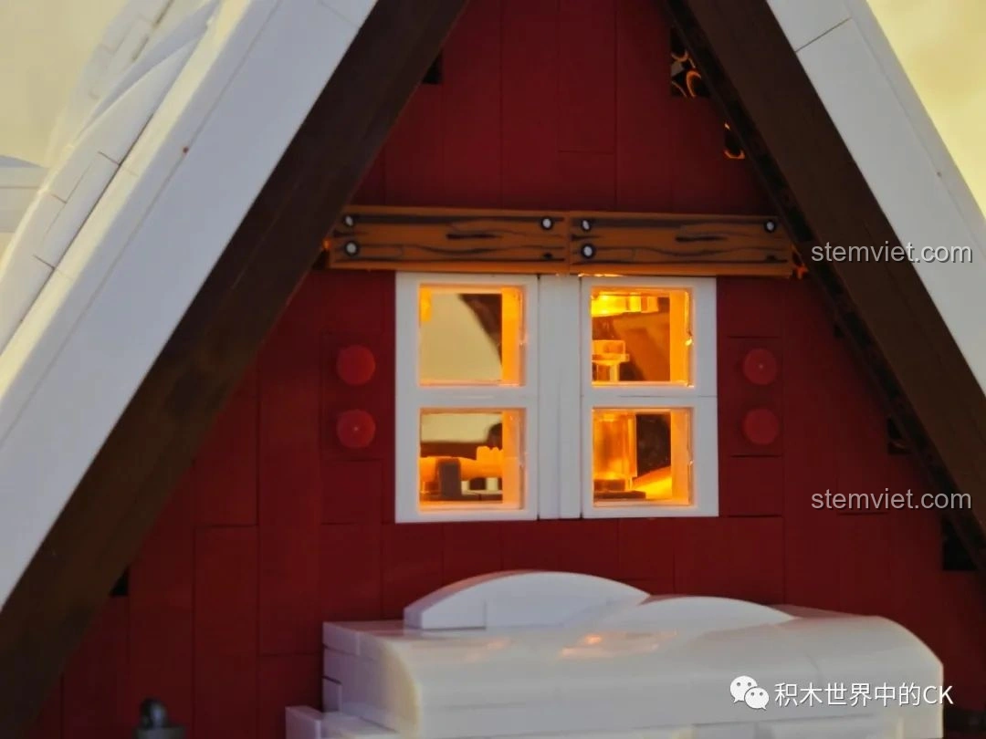 Chi tiết cửa sổ của mô hình JIESTAR 89141 Ngôi nhà Giáng Sinh khi bật đèn LED, ánh sáng vàng ấm áp.