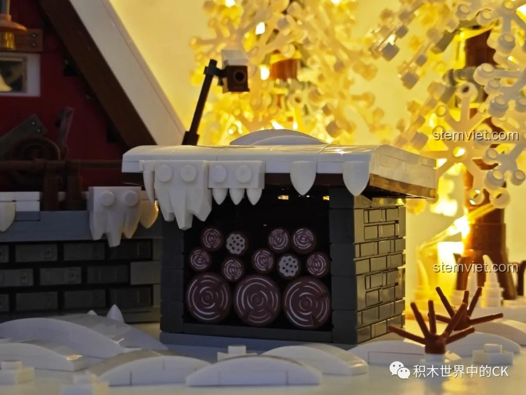 Kho gỗ của mô hình JIESTAR 89141 Ngôi nhà Giáng Sinh khi bật đèn LED, làm nổi bật các khúc gỗ.