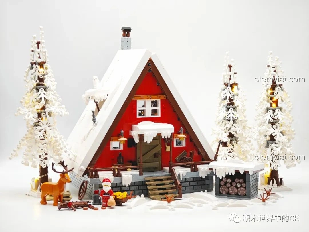 Toàn bộ mô hình JIESTAR 89141 Ngôi nhà Giáng Sinh khi bật đèn LED, nhìn từ góc khác, với cây thông và tuần lộc.