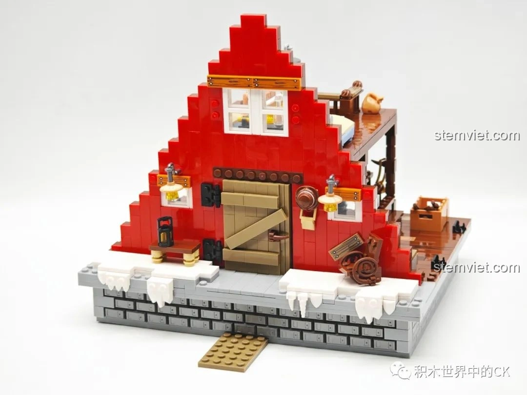 Mặt trước của ngôi nhà JIESTAR 89141 Ngôi nhà Giáng Sinh đang được lắp ráp, với tường đỏ và cửa ra vào.