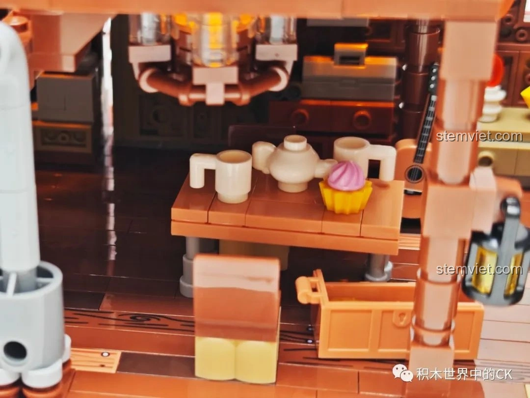 Chi tiết bàn ăn với ấm trà và bánh cupcake bên trong mô hình JIESTAR 89141 Ngôi nhà Giáng Sinh.