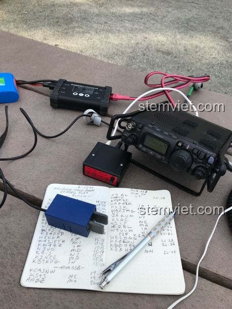 Đồ chơi mô hình Jisi 817, bản sao của máy bộ đàm Ham Radio FT-817, cùng các phụ kiện trên bàn làm việc.