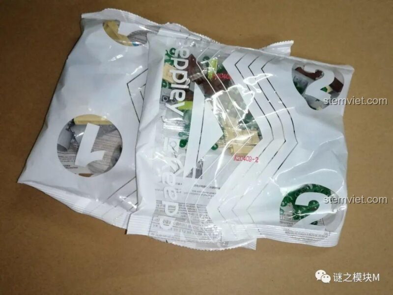 Nội dung bên trong hộp bộ đồ chơi Keeppley K20409 Sân chơi xi măng Doraemon, bao gồm các túi mảnh ghép và sách hướng dẫn.