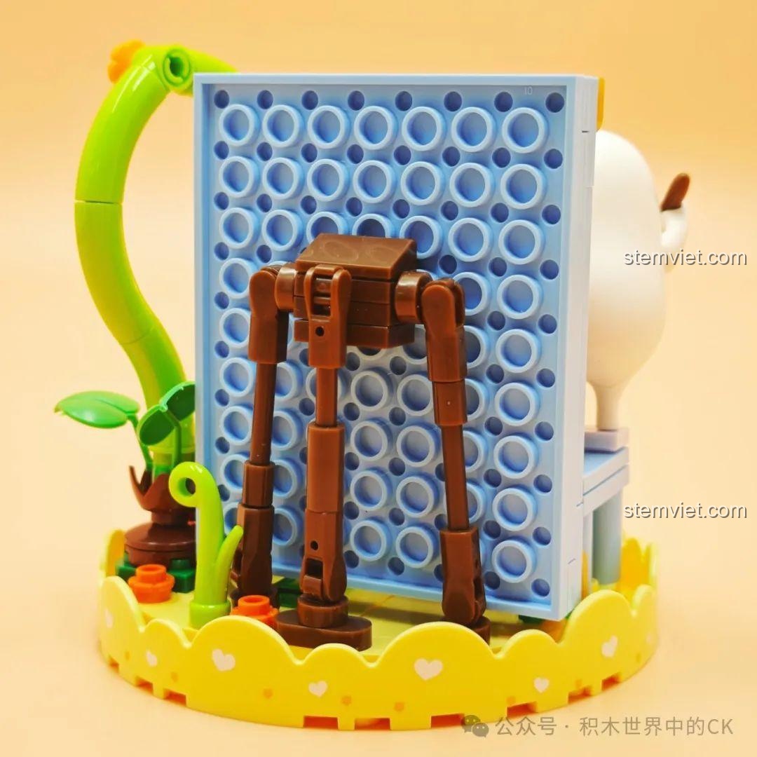 Mặt sau của mô hình SEMBO 612024, cho thấy cấu trúc giá vẽ và tấm nền màu xanh để gắn các chi tiết hoa.