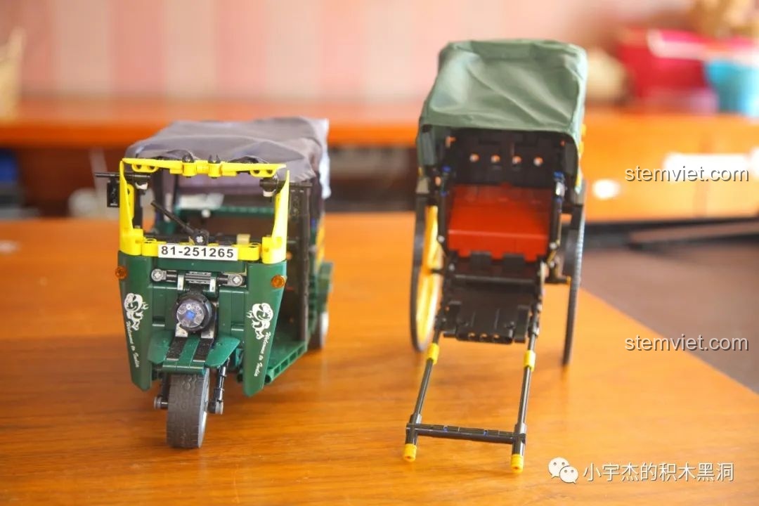 Hai mô hình xe kéo tay và xe lam đặt cạnh nhau, cho thấy sự khác biệt về tỷ lệ và kích thước.