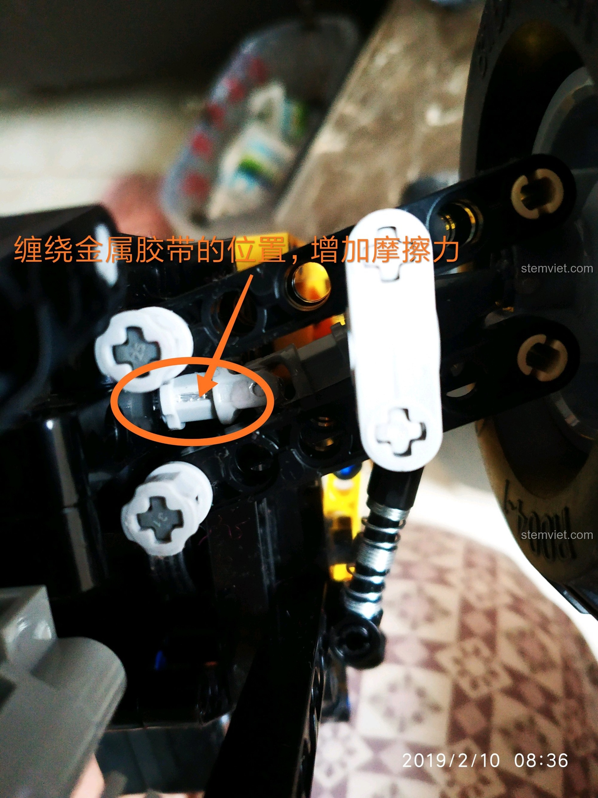 Cận cảnh chi tiết trục bánh xe được gia cố bằng băng keo kim loại trên mô hình CaDA C61016.