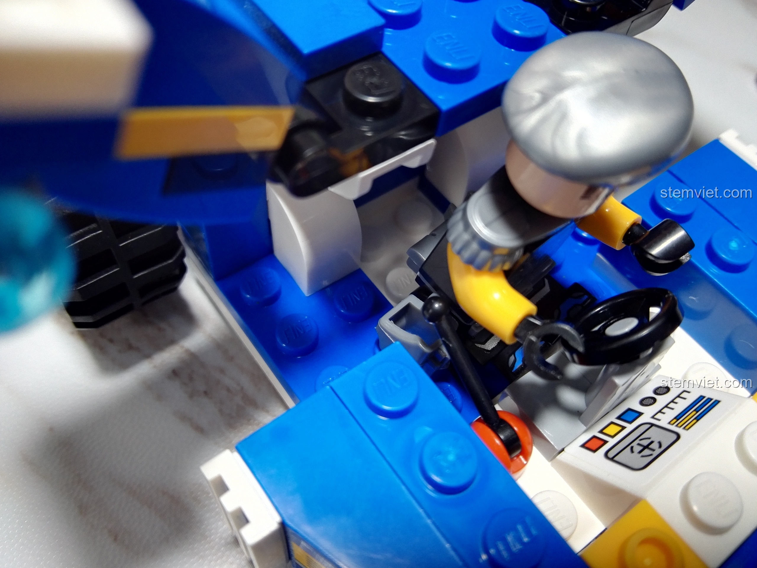 Cận cảnh minifigure Henry đang được đặt vào buồng lái chật hẹp của Xe Trinh Sát Vũ Trang QMAN 2706.