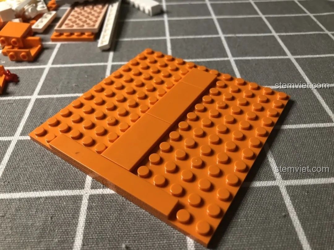 Khung đế màu cam của bộ Wekki 506004 Cảnh Thu đang được lắp ráp, là nền tảng cho mô hình.