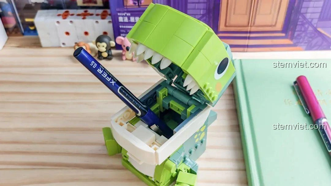 Khủng long T-Rex trong bộ JAKI JK5102 với cây bút trong miệng, cho thấy khả năng chứa đồ.
