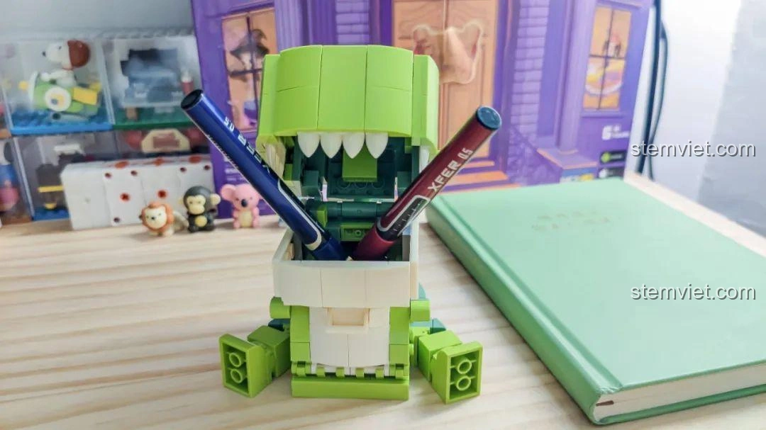 Góc nhìn nghiêng của Khủng long T-Rex trong bộ JAKI JK5102 đang đựng bút, thể hiện tính năng đa năng.