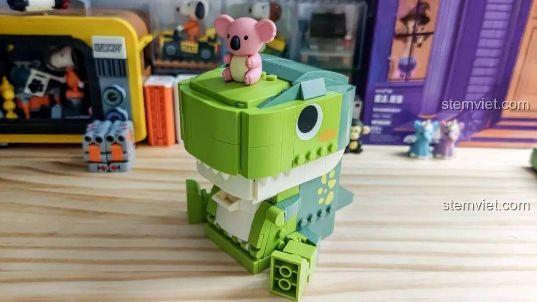 Góc nhìn nghiêng của Khủng long T-Rex trong bộ JAKI JK5102 với gấu Koala trên đầu, tạo điểm nhấn.