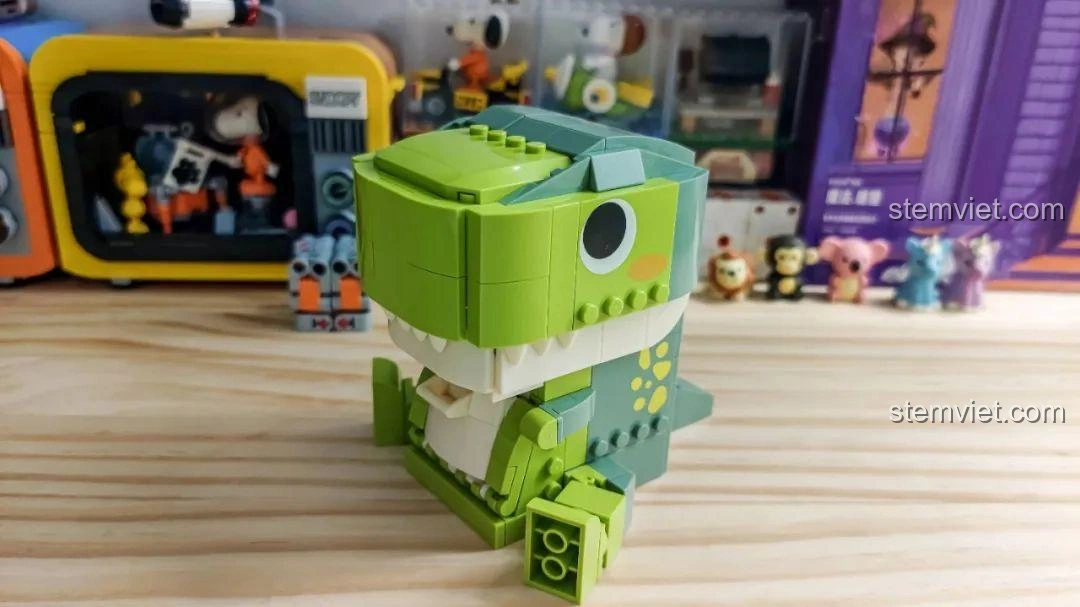 Khủng long T-Rex trong bộ JAKI JK5102 đặt trên bàn gỗ, góc nhìn từ phía sau, hòa mình vào không gian.