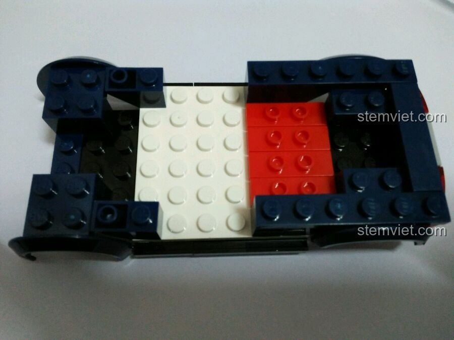 Khung xe cảnh sát của bộ Enlighten 1906 đang được lắp ráp, với các mảnh ghép màu trắng và đỏ.