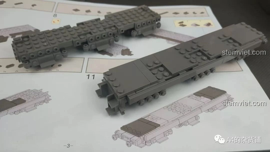 Các mảnh ghép KAZI KY10005 Pháo Xe Lửa Dora 800mm Đức được lắp ráp thành phần khung xe lửa ban đầu, đặt trên sách hướng dẫn.