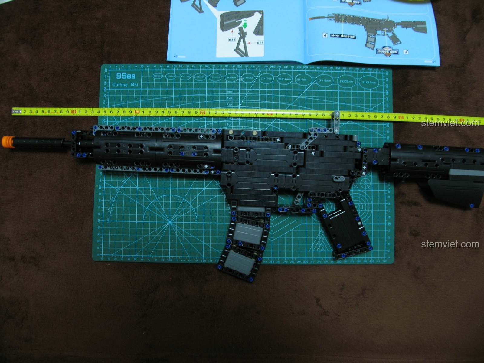 Đo kích thước chiều dài của mô hình súng M4A1 CaDA, đạt khoảng 80cm.
