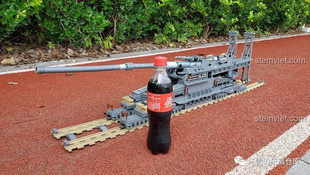 Mô hình Pháo Xe Lửa Dora 800mm Đức KAZI KY10005 đặt cạnh chai nước ngọt để so sánh kích thước thực tế.