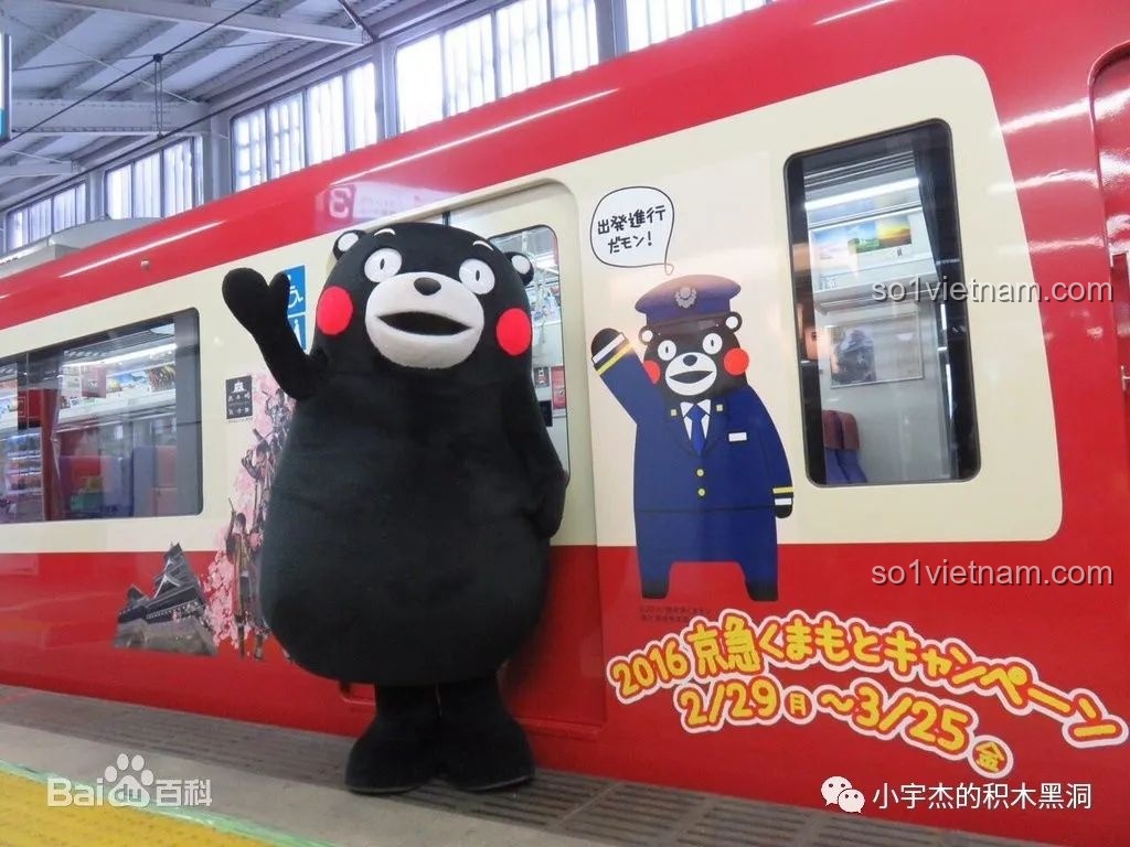 Hình ảnh linh vật Kumamon đáng yêu của tỉnh Kumamoto, Nhật Bản, đứng cạnh tàu hỏa đỏ rực. Một biểu tượng văn hóa nổi tiếng.