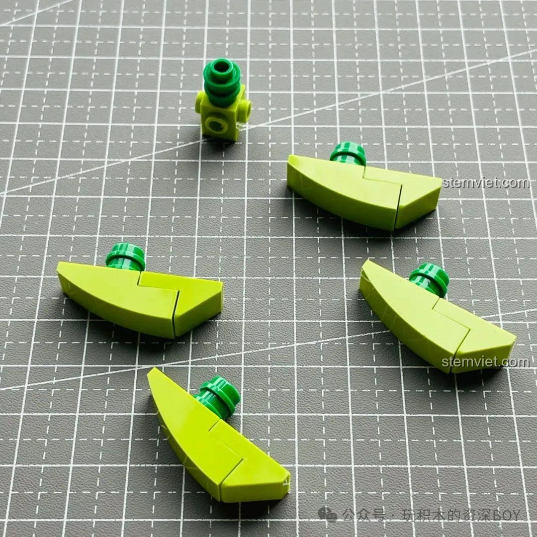 Bốn mảnh lá màu xanh lá cây của mô hình cây xương rồng JAKI JK2727, sẵn sàng để lắp ráp.