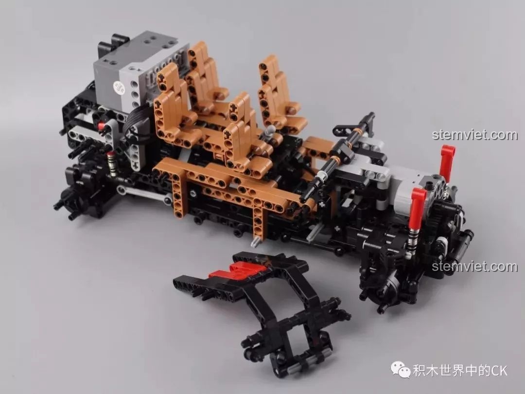 Lắp đặt phần ghế ngồi màu nâu vào khung xe Mould King 13070, tạo sự tương phản với các chi tiết đen.