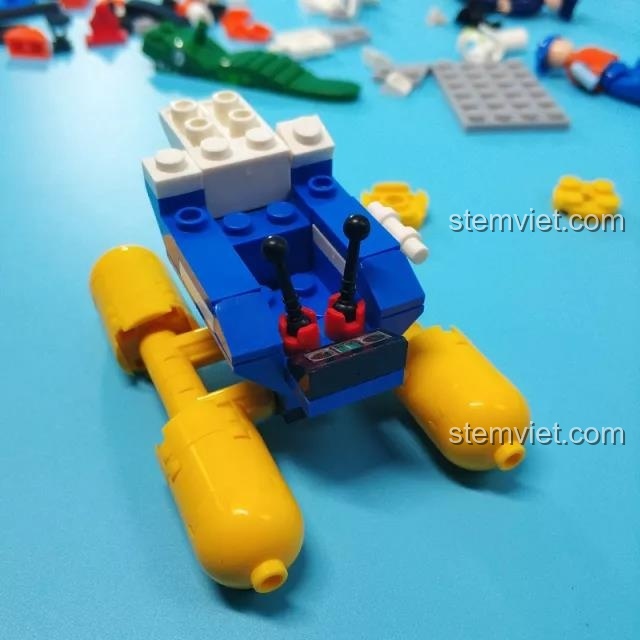 Quá trình lắp ráp phần thân và buồng lái của trực thăng cảnh sát Sluban B0657 với các mảnh ghép màu xanh, trắng và vàng.