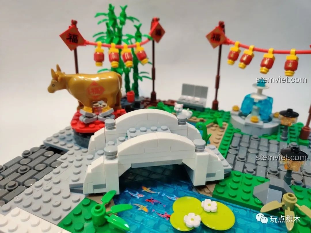 Cây cầu vòm màu trắng được lắp ráp hoàn chỉnh, bắc ngang qua hồ cá trong bộ WOMA C9123.