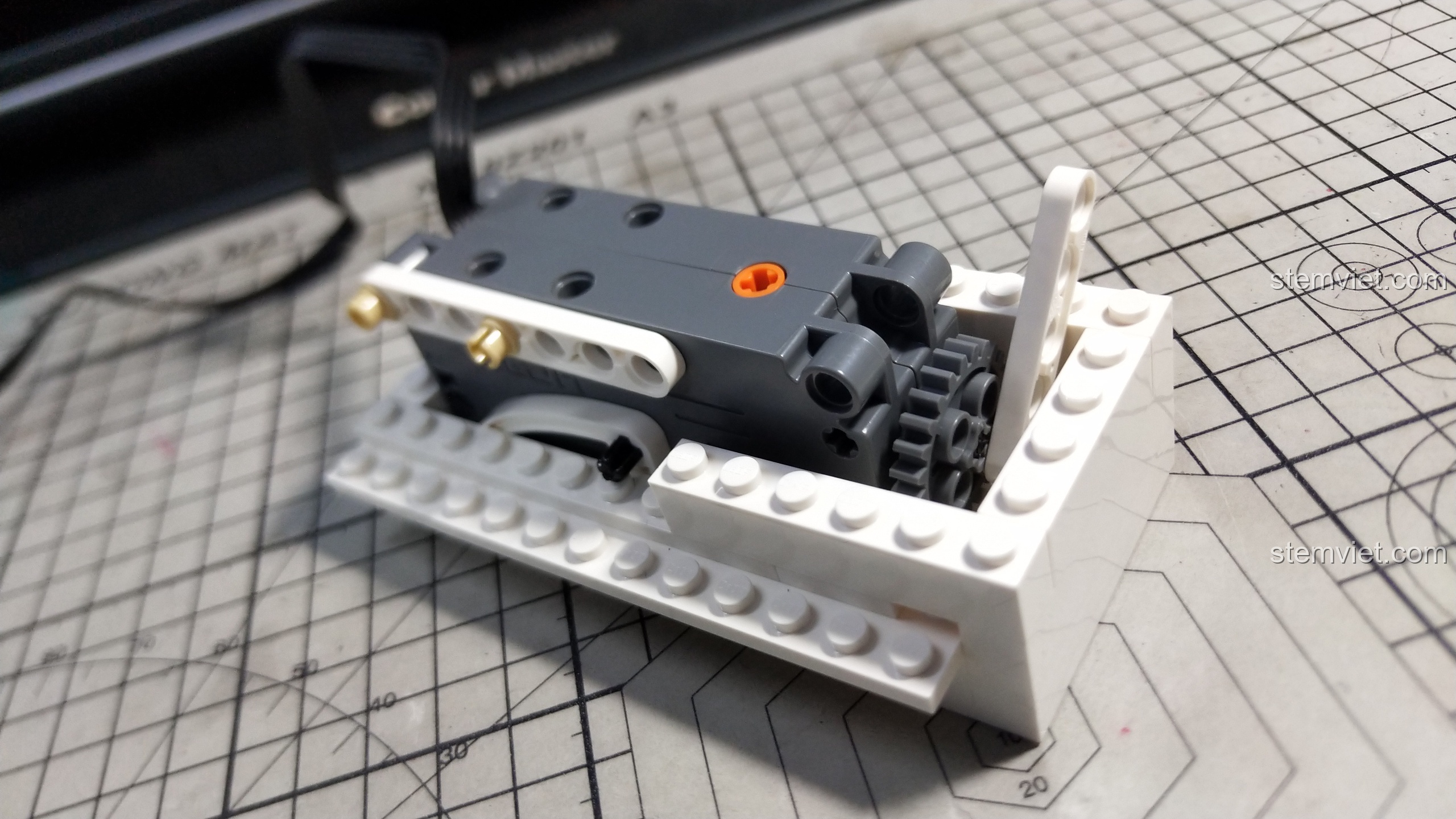 Lắp ráp phần khung đế cho chú heo đất thông minh CaDA C51036, tích hợp khối động cơ vào giữa.