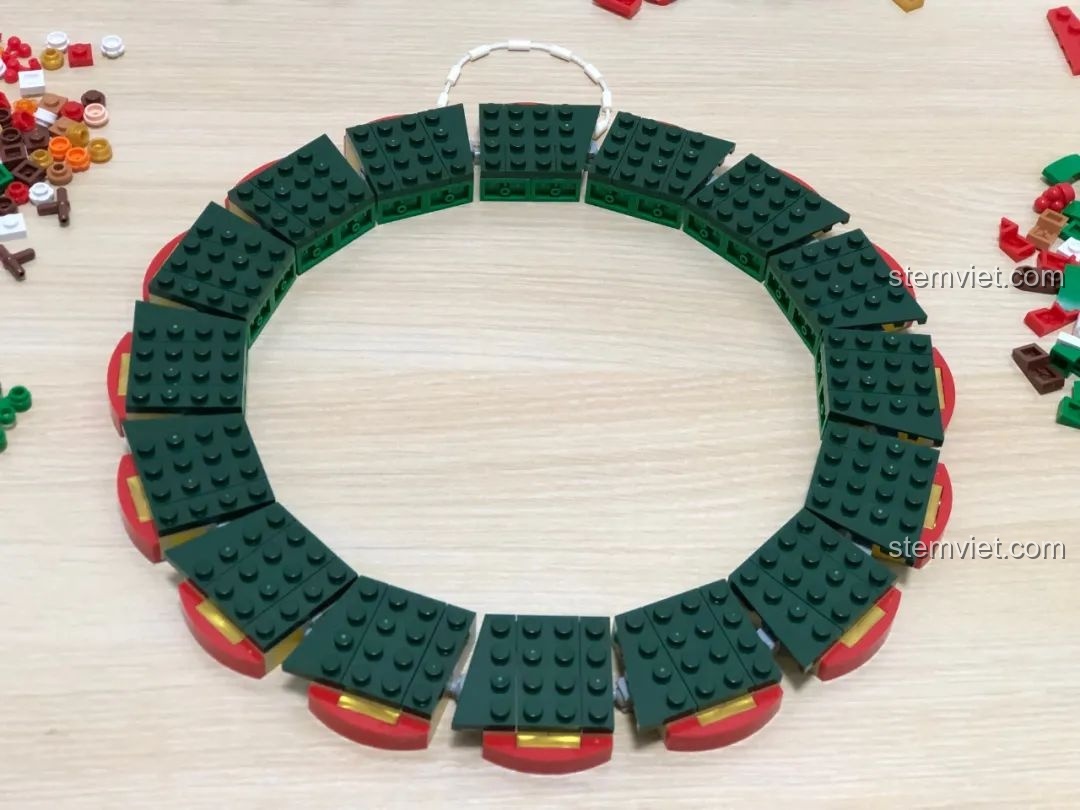 Quá trình lắp ráp phần khung vòng tròn của đồ chơi xếp hình Vòng Hoa Giáng Sinh Đa Sắc JAKI JK5118, dễ dàng và chắc chắn.