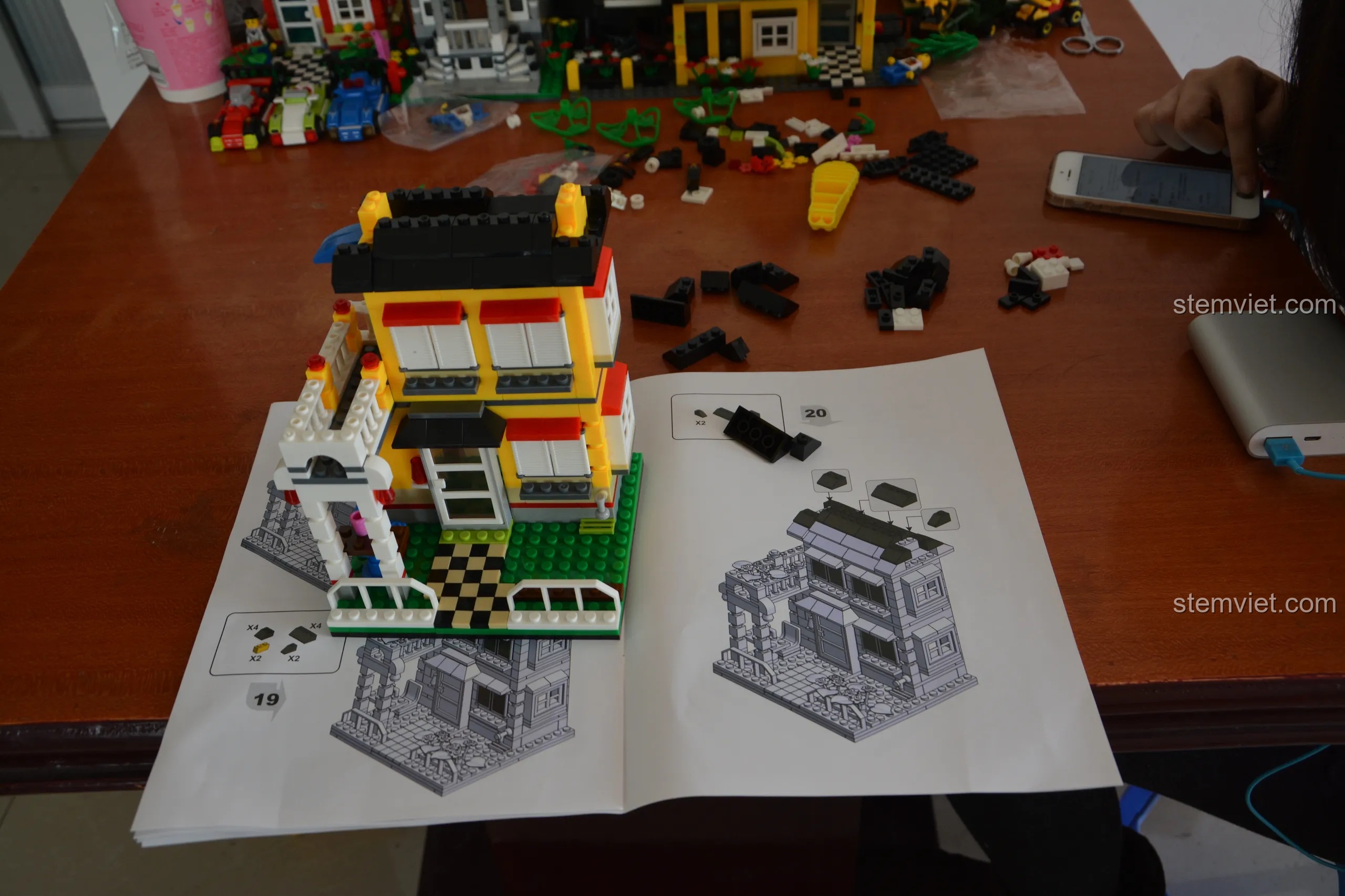 Quá trình lắp ráp ngôi nhà WANGE 31052, cho thấy cấu trúc hai tầng và các chi tiết trang trí.