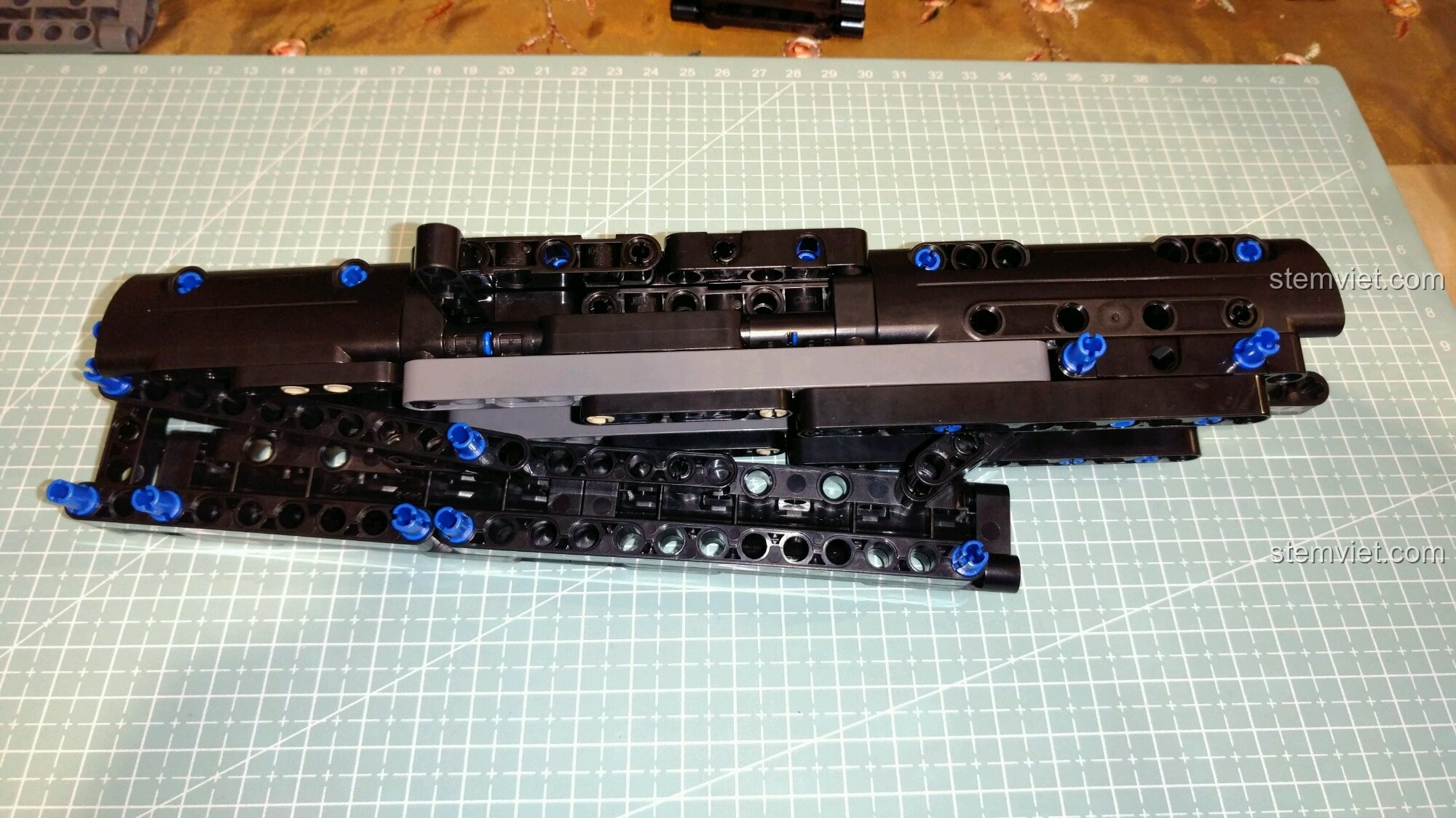 Quá trình lắp ráp phần nòng súng của mô hình CaDA 81006 Súng tiểu liên MP5, sử dụng các tấm panel lớn màu đen.