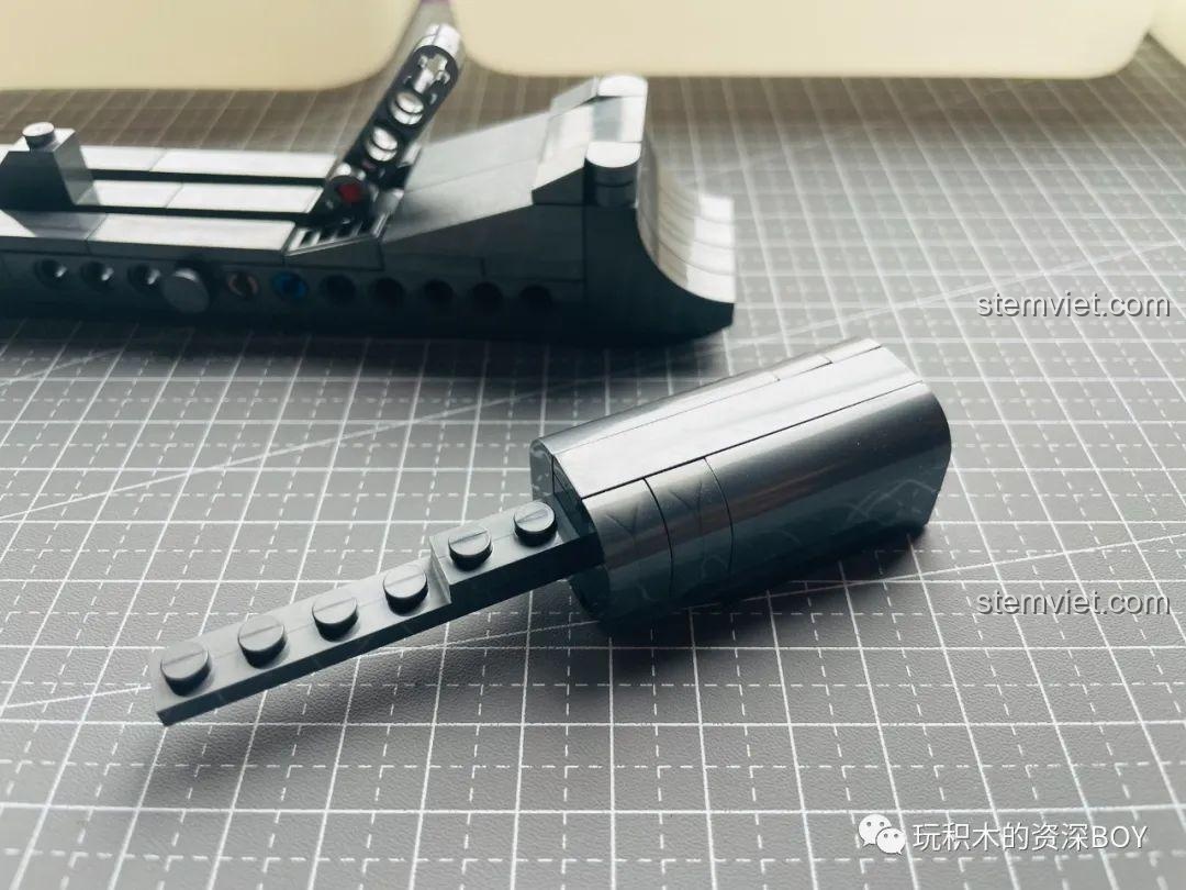 Phần nòng súng của PanlosBrick 670007 M1911 đang được lắp ráp, các mảnh ghép hình trụ tạo độ dài.