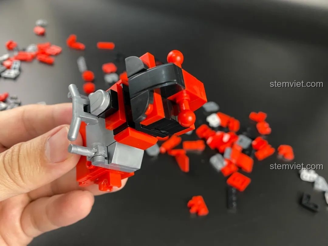Lắp ráp phần lưng của robot Ultraman QMAN 75047, các chi tiết màu đen và đỏ kết hợp hài hòa.