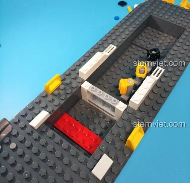 Quá trình lắp ráp phần sàn bên trong của tàu cảnh sát từ bộ Sluban M38-B0657, các chi tiết được gắn vào thân tàu lớn.