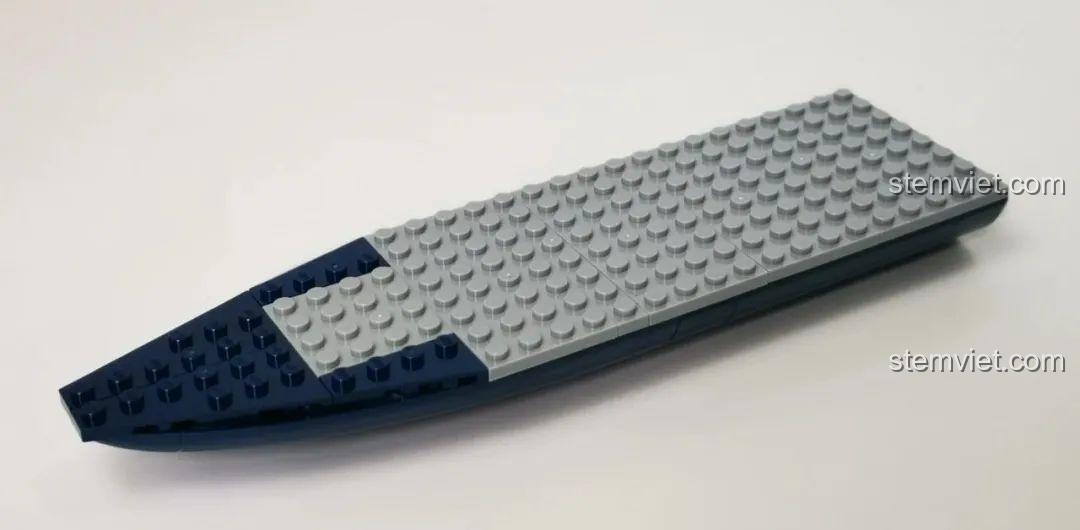 Lắp ráp sàn tàu của tàu công trình GUDI 10804, sử dụng các mảnh ghép phẳng màu xám để tạo bề mặt.