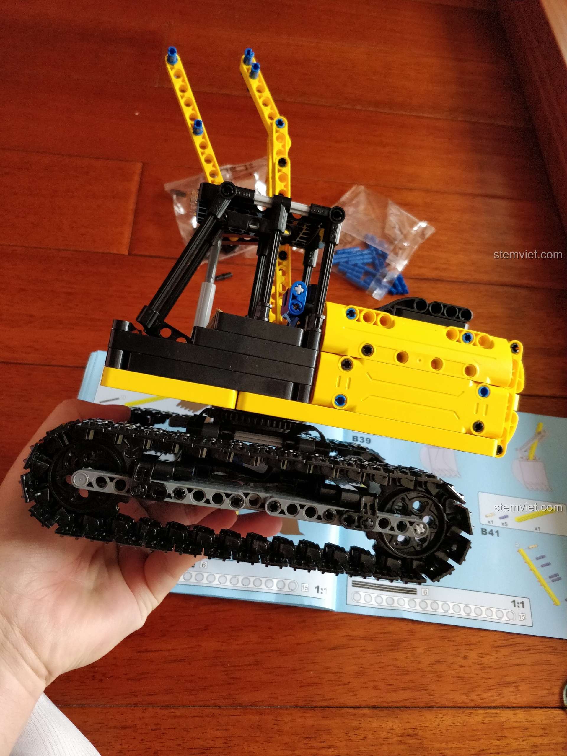 Lắp ráp phần tay gầu cuối cùng của đồ chơi xây dựng CaDA đáng tiền, với chi tiết giảm xóc lò xo.