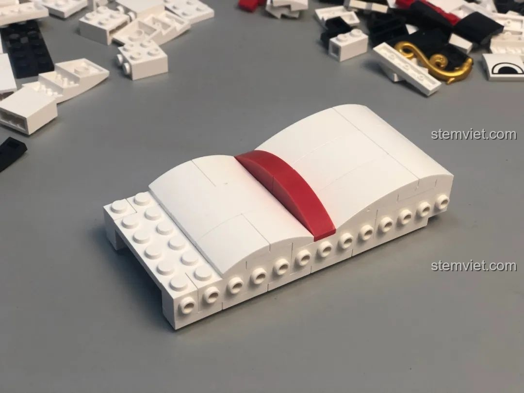 Quá trình lắp ráp phần thân dưới của Bút Đựng Bút Người Tuyết JAKI, các mảnh ghép trắng tinh khôi.