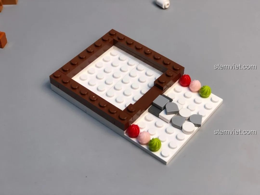 Thân Nhà Bánh Gừng JAKI đang được lắp ráp, có cửa mở và các chi tiết trang trí kẹo.