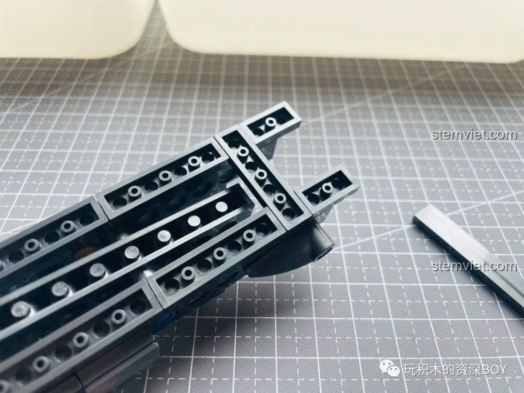 Phần thân súng PanlosBrick 670007 Súng Lục M1911 đang được lắp ráp, các lớp mảnh ghép chồng lên nhau tạo khối.