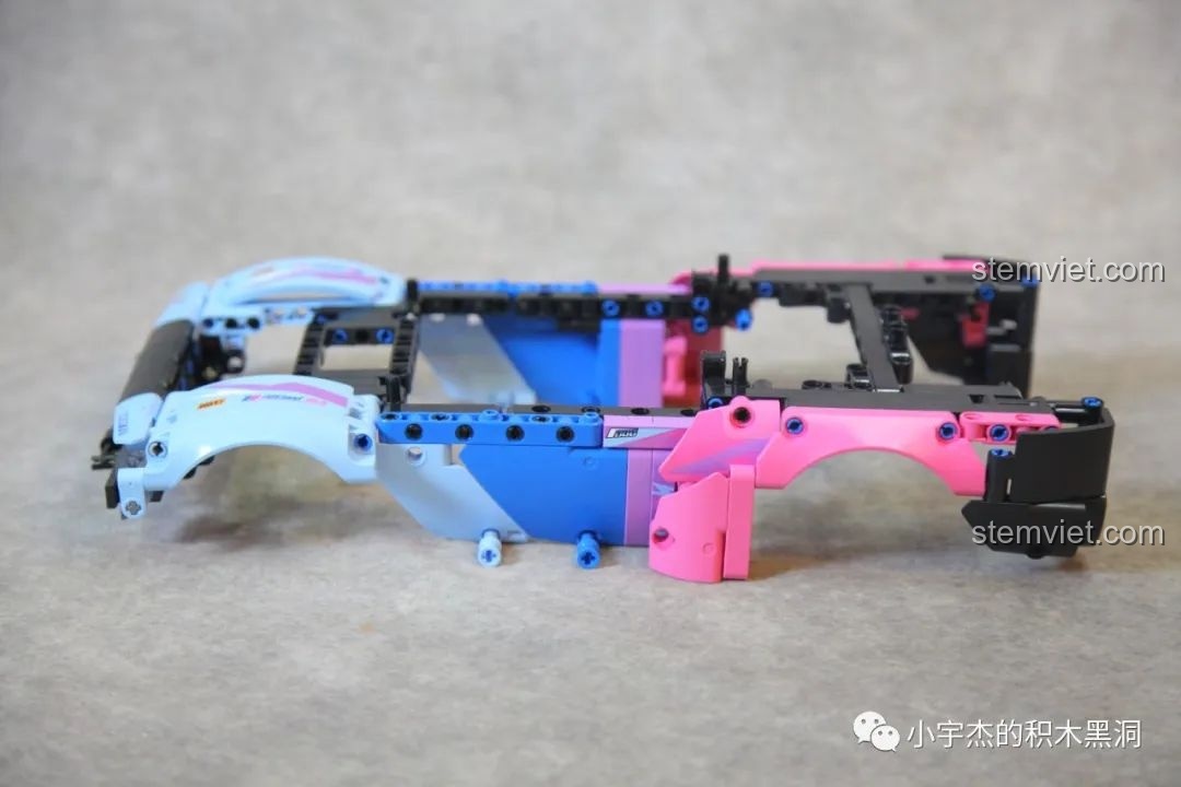 Phần thân vỏ của xe SEMBO 715006 đang được lắp ráp, với các mảng màu hồng và xanh.