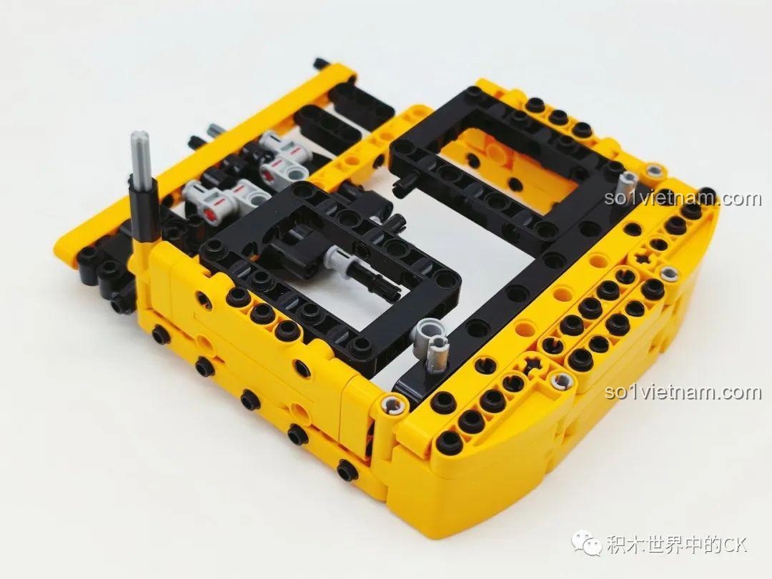 Quá trình lắp ráp phần thân trên của mô hình xe xúc Sembo 712017, kết hợp các chi tiết Technic màu vàng và đen.