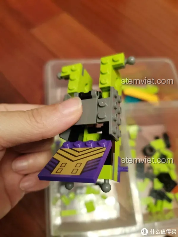 Bàn tay đang lắp ráp phần thân của xe tải chở đất, một chi tiết quan trọng trong bộ Robot Biến Hình Đại Lực Thần SEMBO 103081, với các khớp nối màu xám.